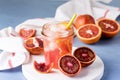 Glass Jar of Squeezing Juice from Orange Cold Orange Juice with Red Orange Ice Cubes Healthy Drink Blue Background Royalty Free Stock Photo