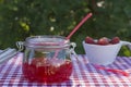 A glass jar with strawberry jam, a bowl with strawberries Royalty Free Stock Photo