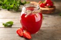 Glass jar with strawberry jam on wooden table Royalty Free Stock Photo