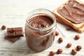 Glass jar with tasty chocolate cream, bread and hazelnuts Royalty Free Stock Photo