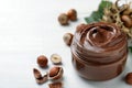 Glass jar with tasty chocolate spread and hazelnuts on white wooden table, space for text Royalty Free Stock Photo