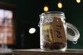 Glass jar with tips on wooden table indoors, closeup. Space for text Royalty Free Stock Photo