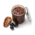 Glass jar with traditional homemade black olive tapenade close up on white background