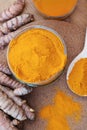 Glass jar of turmeric powder and roots on wooden table, flat lay Royalty Free Stock Photo
