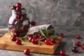 Glass jar and wooden board with fresh ripe cherries on grey textured background Royalty Free Stock Photo