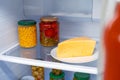 Glass jars of canned products on a fridge shelf