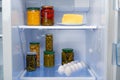 Glass jars of canned products on a fridge shelf
