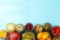 Glass jars with different pickled vegetables on light blue wooden table, flat lay. Space for text Royalty Free Stock Photo