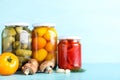 Glass jars with different pickled vegetables on blue wooden table. Space for text Royalty Free Stock Photo