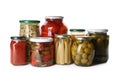 Glass jars with different pickled vegetables and mushrooms on background