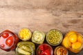 Glass jars with different pickled vegetables on wooden table, flat lay. Space for text Royalty Free Stock Photo