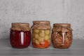 Glass jars with different preserved vegetables and mushrooms on wooden table Royalty Free Stock Photo