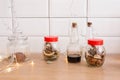 Glass jars of dried fruit, bottled sauce and Christmas lights in a Scandinavian kitchen Royalty Free Stock Photo