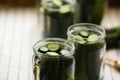 Glass jars with fresh cucumbers prepared for canning against blurred background, closeup Royalty Free Stock Photo