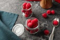 Glass jars with fresh ripe raspberries on table