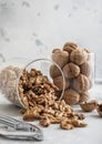 Glass jars with healthy raw walnut whole and peeled nuts on white kitchen table.Macro Royalty Free Stock Photo