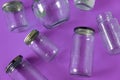 Glass jars with lids, purple background, top view flat lay recycling concept