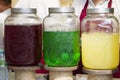 Glass jars with multi-colored lemonade. Bright summer drinks with fruits and herbs