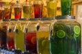 Glass jars with multi-colored lemonade. Bright summer drinks with fruits and herbs