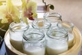 Glass jars with natural homemade organic yogurt in yogurt maker. Nearby is a delicate pink orchid flower Royalty Free Stock Photo