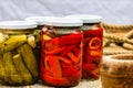 Glass jars with pickled red bell peppers and pickled cucumbers pickles isolated. Jars with variety of pickled vegetables.