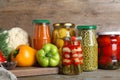Glass jars with pickled vegetables on wooden table Royalty Free Stock Photo