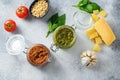 Glass jars with red and green pesto and cooking ingredients Parmesan cheese, basil leaves, pine nuts, olive oil, garlic, salt, Royalty Free Stock Photo