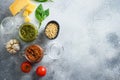 Glass jars with red and green pesto and cooking italian recipe ingredients Parmesan cheese, basil leaves, pine nuts, olive oil, Royalty Free Stock Photo