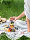 Glass jars with a salad of fruits and berries in the hands of a woman. Seasonal healthy healthy vegetarian food for a picnic. Royalty Free Stock Photo