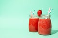 Glass jars strawberry cocktail on mint background. Summer drink