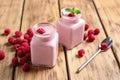 Glass jars of tasty smoothie with raspberries on table Royalty Free Stock Photo