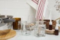 Glass jars with wicks on white kitchen table. Making homemade candles Royalty Free Stock Photo