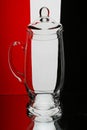 Glass jug against a black-red and white background Royalty Free Stock Photo