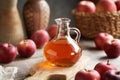 A glass jug of apple cider vinegar with fresh apples on a table Royalty Free Stock Photo