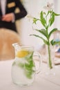 Glass jug of cold lemonade on a light background cafe. Pitcher lemon water with mint. Cold lemonade box Royalty Free Stock Photo