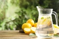 Glass jug of cold lemonade on wooden table. Space for text Royalty Free Stock Photo