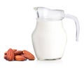 Glass jug of fresh milk and almonds isolated on white. Royalty Free Stock Photo