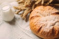 Glass jug with milk and bread on white textile Royalty Free Stock Photo