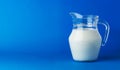 Glass jug of milk isolated on blue background with copy space Royalty Free Stock Photo