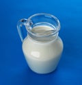 Glass jug of milk isolated on blue background, top view Royalty Free Stock Photo