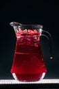 glass jug with refreshing cherry lemonade fizzy drink or ice on black background Royalty Free Stock Photo