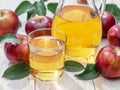 Glass of juice and carafe of fresh apple juice and organic apples on wooden table Royalty Free Stock Photo