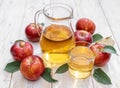 Glass of juice and carafe of fresh apple juice and organic apples on wooden table Royalty Free Stock Photo