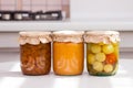 Glass jurs of various preserved, canned foon in the kitchen in sunny day