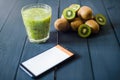 Glass of kiwi juice with fresh fruits on wooden table Royalty Free Stock Photo