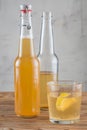 The glass of Kombucha drink with lemon and two bottles. Royalty Free Stock Photo