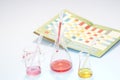 Glass laboratory apparatus with chemicals and book Royalty Free Stock Photo