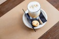 glass of Latte Macchiato with spoon, straw and plate with cookies on a wooden table.Delicious sweet breakfast. Coffee Royalty Free Stock Photo