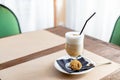 glass of Latte Macchiato with spoon, straw and plate with cookies on a wooden table.Delicious sweet breakfast. Coffee Royalty Free Stock Photo