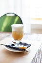 glass of Latte Macchiato with spoon, straw and plate with cookies on a wooden table.Delicious sweet breakfast. Coffee Royalty Free Stock Photo
